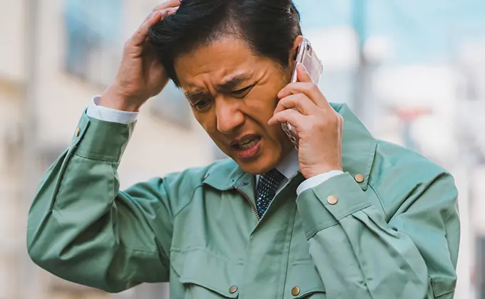電話がつながらず困っている男性の画像
