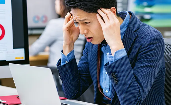 PCが壊れて困っている男性の画像